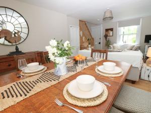 a living room with a table with dishes on it at Fern Cottage in Bembridge
