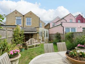 a backyard with chairs and a bench in the yard at Fern Cottage in Bembridge