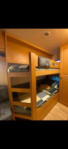 a bunk bed with wooden shelving in a room at Caravana Camping Coelius in Miramar
