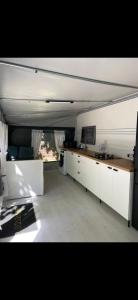 a room with a kitchen with white cabinets and a window at Caravana Camping Coelius in Miramar
