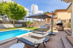a swimming pool with two lounge chairs and an umbrella at Villa Ramón in Palma de Mallorca