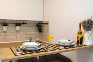 a table with two plates and glasses of wine at Apartments Milas in Okrug Gornji +150 photos