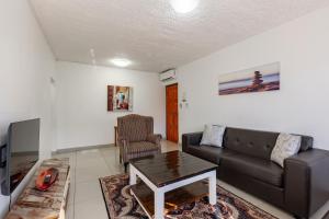 a living room with a couch and a table at Safi Self-Catering Suite 1 in Bunkers Hill +4 photos