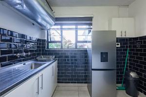 a kitchen with a sink and a refrigerator at Safi Self-Catering Suite 1 in Bunkers Hill