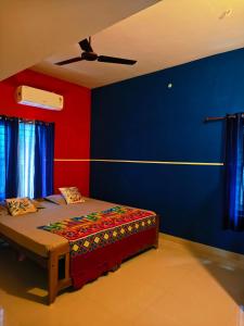 a bedroom with a bed with blue and red walls at Phoenix Villa in Kappil