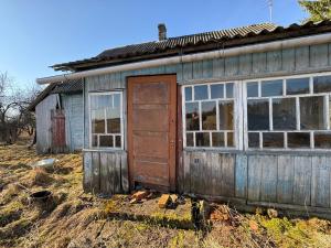 an old wooden building with a door and windows at The White MEADOW in Titova