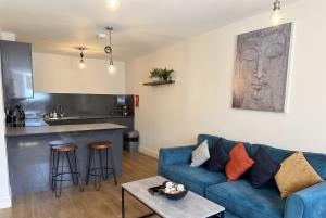 a living room with a blue couch and a kitchen at Large central studio Sleep 3 in Brighton & Hove