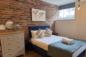 a bedroom with a bed and a brick wall at Large central studio Sleep 3 in Brighton & Hove