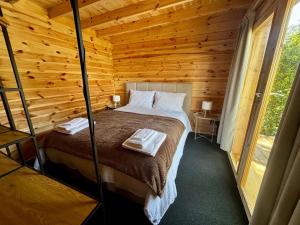 a bedroom with a bed in a wooden cabin at Encanto de Azeitão in Aldeia de Irmãos +13 photos
