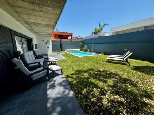 a backyard with two chairs and a swimming pool at Encanto de Azeitão in Aldeia de Irmãos