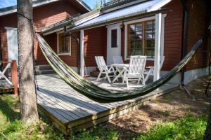 a hammock on a porch of a house at Sappee Peak Cabin - Bike, Fire, Snow & Adventure in Salmentaka