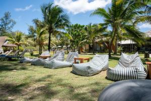 a group of chairs sitting on the grass with palm trees at Garden Chalets Koh Lanta in Ko Lanta