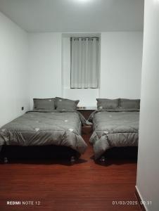 a bedroom with two beds and a window at HOTEL CASA RUSTICA Jr CALLAO 264 HUAMANGA AYACUCHO in Ayacucho +16 photos