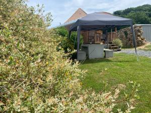 a gazebo with a black canopy in a yard at La champ être in Neuville-sur-Sarthe