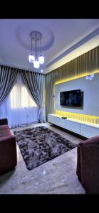 a living room with a couch and a television at IFY LUXURY APARTMENTs in Maitama