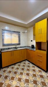 an empty kitchen with wooden cabinets and a window at IFY LUXURY APARTMENTs in Maitama