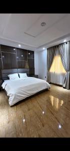 a bedroom with a large white bed and a window at IFY LUXURY APARTMENTs in Maitama