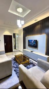 a living room with two couches and a flat screen tv at IFY LUXURY APARTMENTs in Maitama