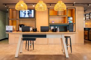 a large table in a room with two lights at Ibis Porto Alegre Assis Brasil - Estacionamento Gratuito para hospedes in Porto Alegre