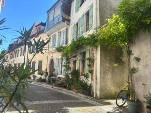a street in an old building with plants and a bike at Gîte casa cosy in Salies-de-Béarn