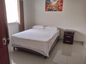a bedroom with a bed and a night stand at Mi casa, moderna B in Vila El Carmen