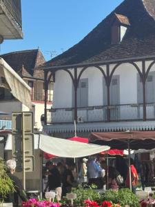 a group of people sitting under umbrellas in front of a building at Gîte casa cosy in Salies-de-Béarn +4 photos