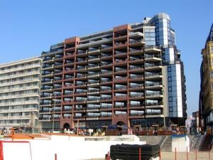 a large apartment building in front of a beach at Bristol Palace Seaview 7e verdieping, 30 meter van strand in Blankenberge
