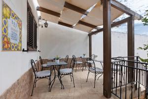a patio with tables and chairs on a balcony at Bnb La Rocca San Vito Lo Capo in San Vito lo Capo
