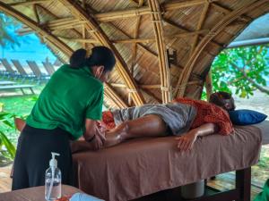 a woman standing next to a man laying on a bed at Garden Chalets Koh Lanta in Ko Lanta