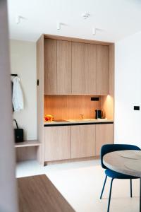 a kitchen with wooden cabinets and a table at TWILL Apartments in Brno +31 photos