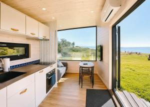 a kitchen in a tiny house with a large window at Tiny Seaside - Skarrev in Aabenraa