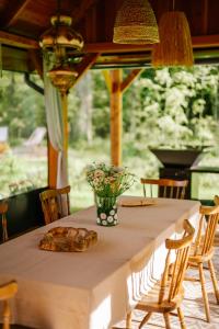 a long table with a vase of flowers on it at Gardiasówka na Roztoczu in Chlewiska