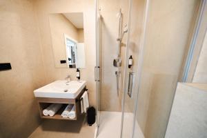 a bathroom with a sink and a shower at TWILL Apartments in Brno