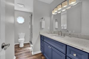 a bathroom with a sink and a toilet and a mirror at All Marshed Up-Stunning Water View 1 block to beach in Surf City +49 photos
