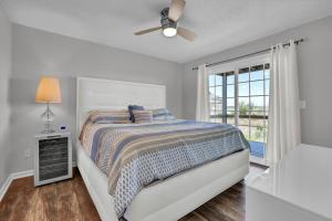 a white bedroom with a bed and a window at All Marshed Up-Stunning Water View 1 block to beach in Surf City