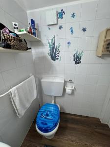 a bathroom with a toilet with a blue seat at Attico Vicky in Porto Azzurro +17 photos