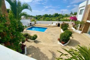 a backyard with a swimming pool and plants at Gorgeous Beach house 3BD Pool and BBQ in Punta Blanca