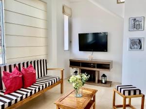 a living room with a couch and a tv at Gorgeous Beach house 3BD Pool and BBQ in Punta Blanca