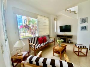 a living room with a couch and a tv at Gorgeous Beach house 3BD Pool and BBQ in Punta Blanca