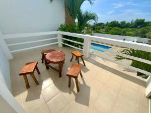 a balcony with two tables and two stools on it at Gorgeous Beach house 3BD Pool and BBQ in Punta Blanca
