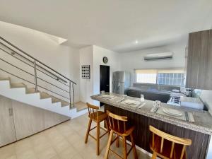 a kitchen with a bar with chairs and a counter top at Gorgeous Beach house 3BD Pool and BBQ in Punta Blanca +10 photos