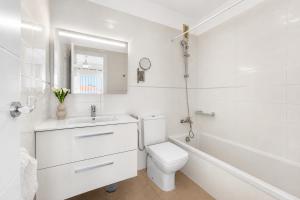 a white bathroom with a toilet and a sink at DUPLEX C9 con PISCINA PRIVADA in Callao Salvaje +7 photos