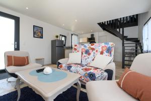 a living room with a couch and chairs and a table at Ker Marin -Maison Refuge Des Marées in Sarzeau