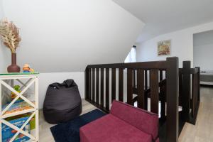 a room with a crib and a purple chair at Ker Marin -Maison Refuge Des Marées in Sarzeau