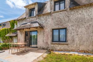 a stone house with a table and chairs outside at Ker Marin -Maison Refuge Des Marées in Sarzeau