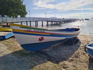 a boat sitting on the beach next to a pier at Ipê Eco Village, Apartamentos perto do Beto Carrero in Penha +15 photos