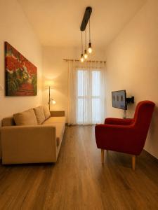 a living room with a couch and a red chair at Primero el Wiro in Puerto