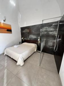 a bedroom with a bed and a glass shower at Stanza dei Desideri in Peschici