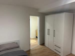 a bedroom with a bed and a white cabinet at Ferienwohnung Elli in Haiterbach