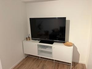 a flat screen tv sitting on top of a white entertainment center at Ferienwohnung Elli in Haiterbach